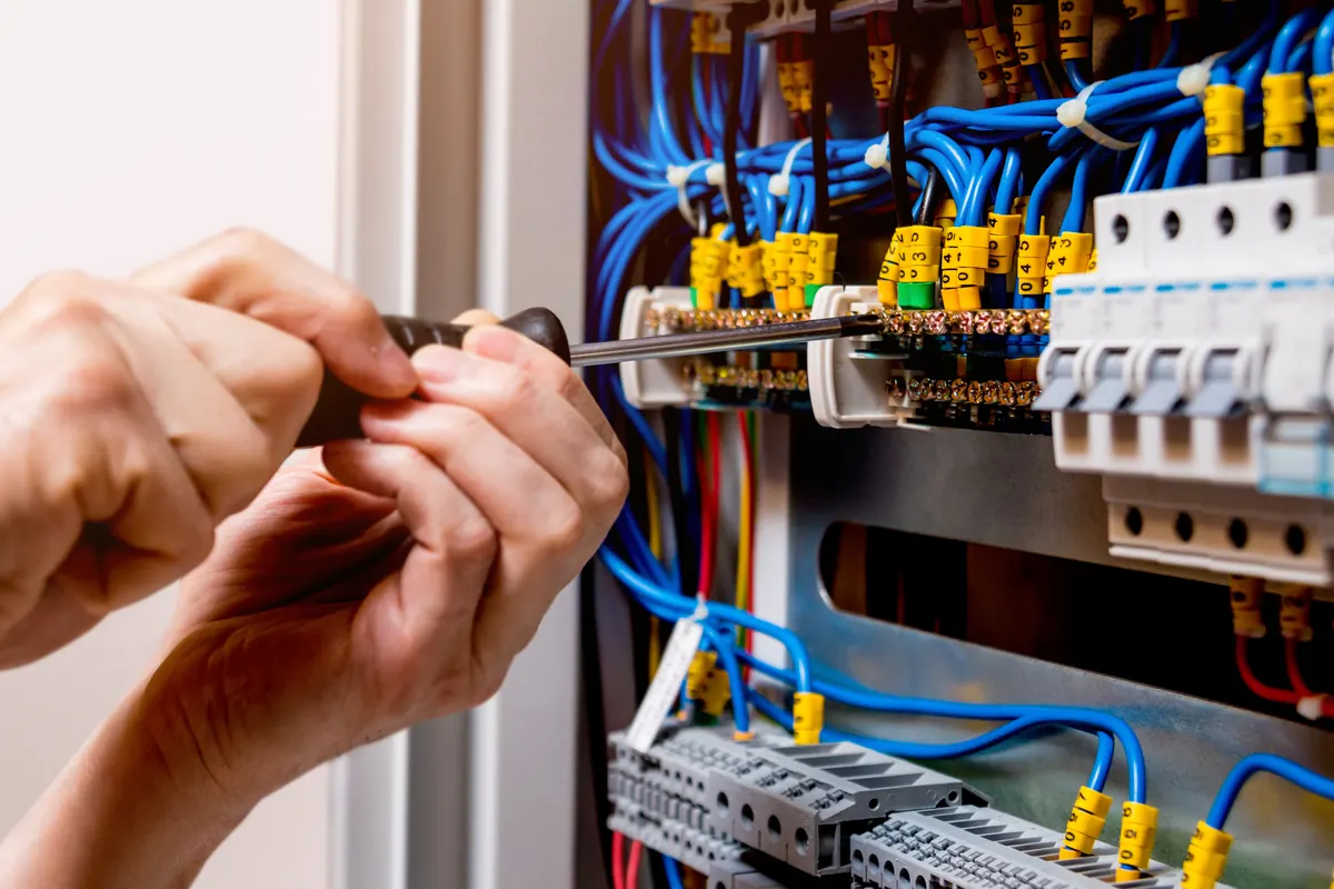 Electrician terminating cables inside a consumer unit