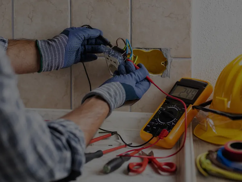Electrician testing a circuit with a multimeter during an electrical inspection